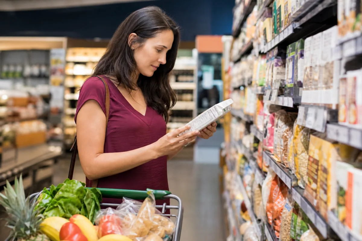Persona revisando etiquetas nutricionales en el supermercado