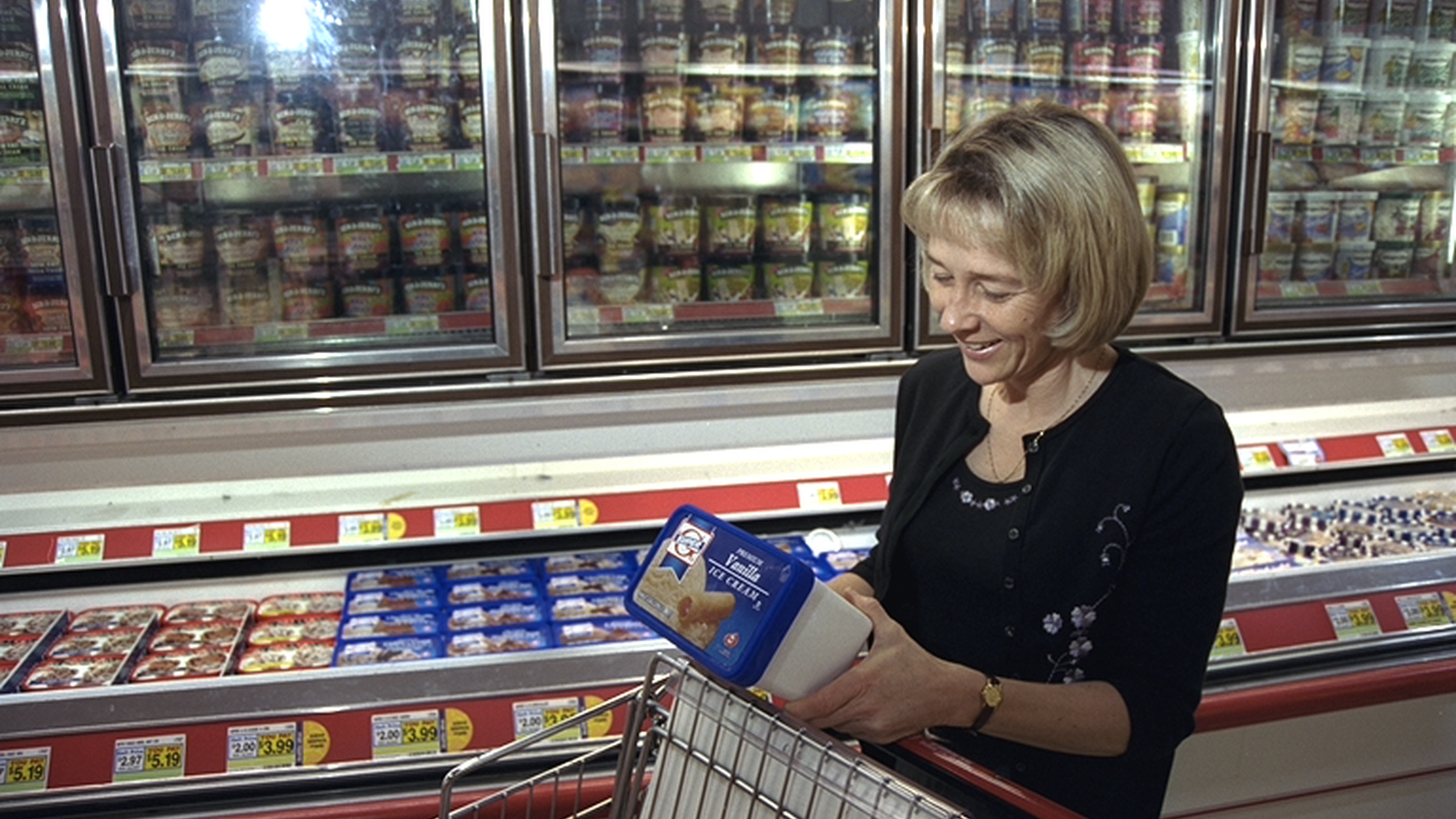 Mujer comparando etiquetas de sal y sodio en productos del supermercado